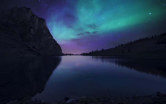 Aurora Borealis over a mountain lake at night