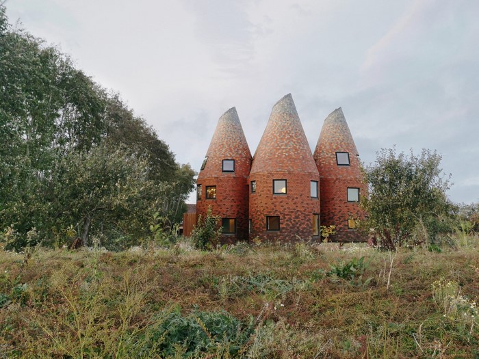 Unusual conical brick houses in a field
