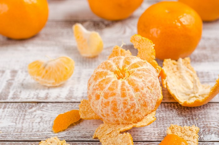 Peeled tangerines and peels on a wooden table