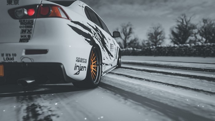 Mitsubishi Lancer Evo X with orange wheels in snow
