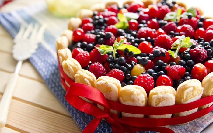 Berry Charlotte cake with ladyfingers and red ribbon