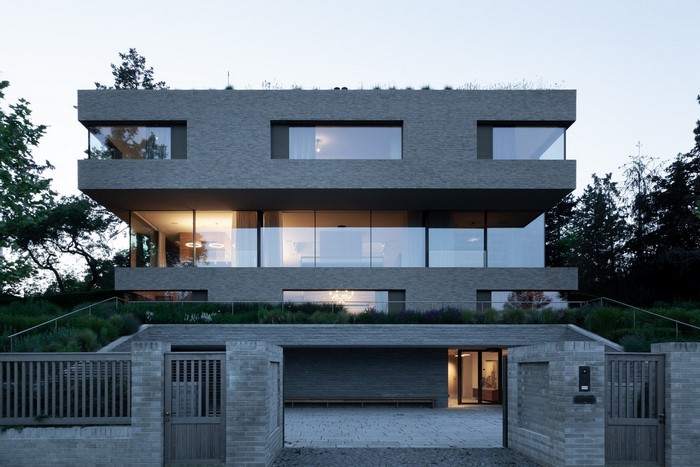 Modern brick house with large windows and green roof