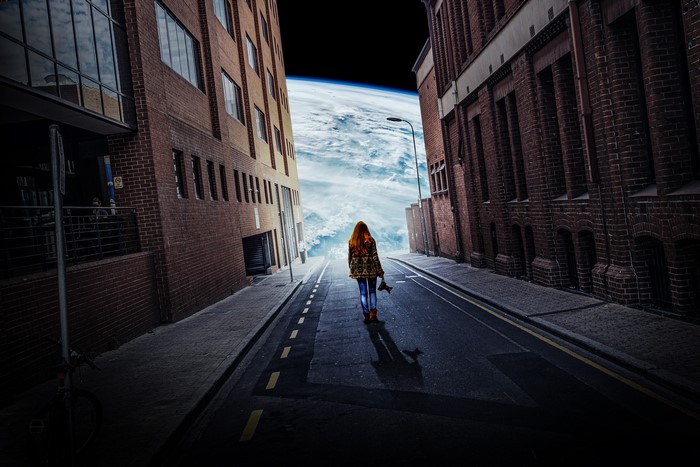 Woman walking towards Earth from city street