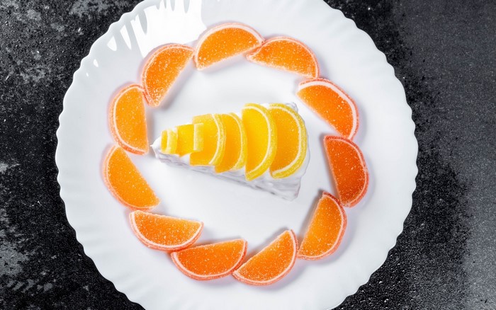 Slice of cake with orange and yellow jelly slices on a plate