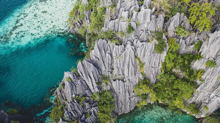 Aerial view of limestone rock formations and turquoise waters in the Philippines
