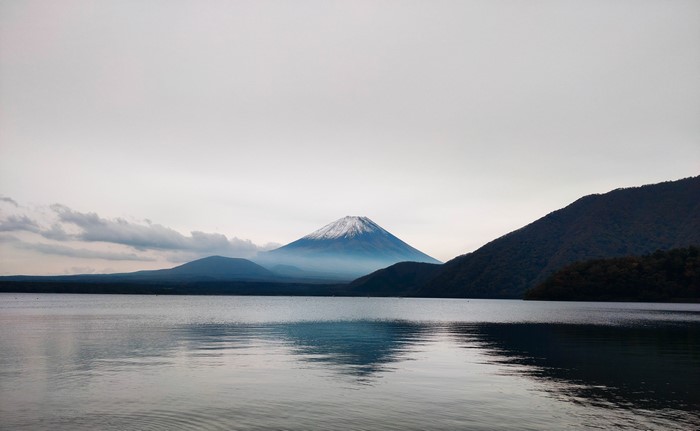 Mount Fuji with snowy peak over a lake