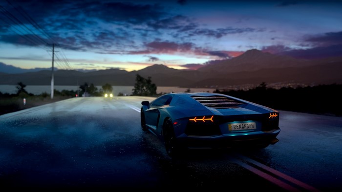 Blue Lamborghini Aventador on a wet road at dusk