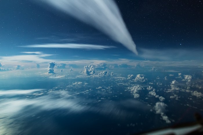 Aerial view of clouds and stars from above the atmosphere