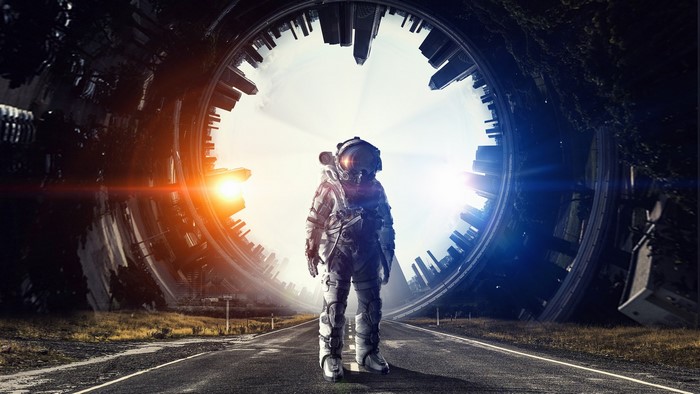Astronaut standing on a road with a futuristic portal