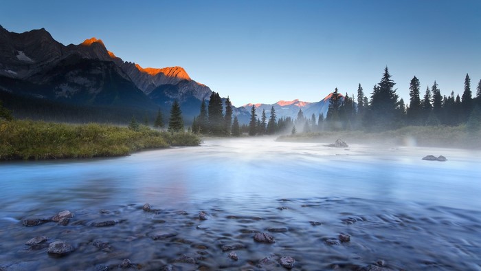 River mist at sunrise with mountains and trees in British Columbia