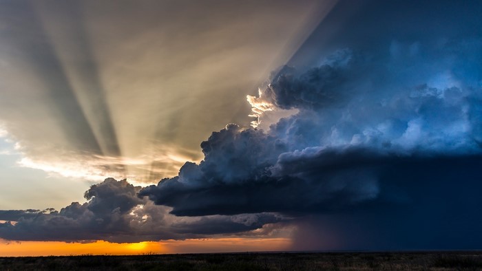 Stormy sunset with crepuscular rays over a prairie