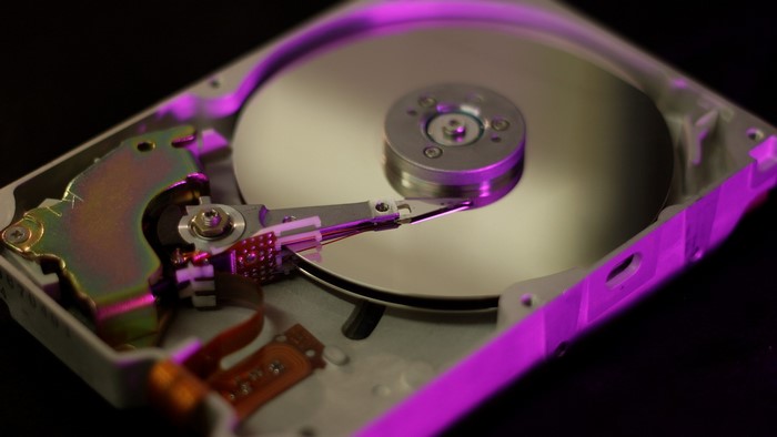 Close-up of an open hard drive with purple lighting