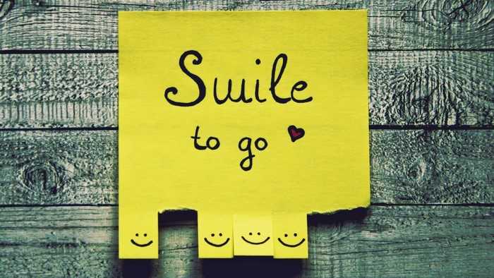 Yellow sticky note with "Smile to go" and smiley faces