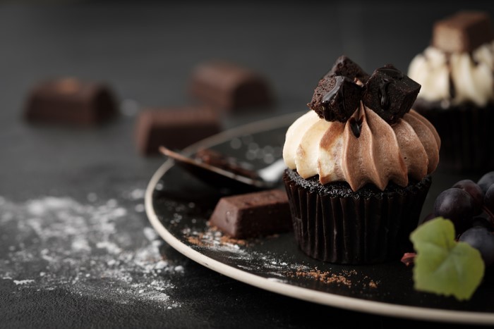 Chocolate cupcake with frosting and chocolate pieces