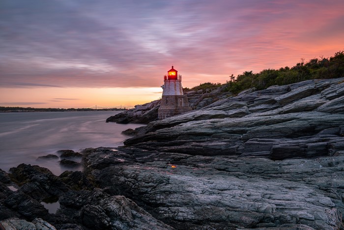 4K lighthouse on rocky coast at sunset