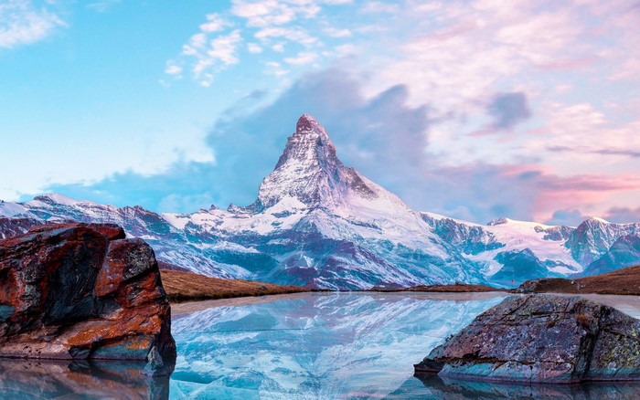 Matterhorn mountain reflected in a lake with rocks