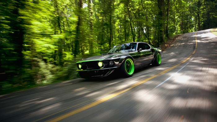 Modified Ford Mustang driving on a forest road