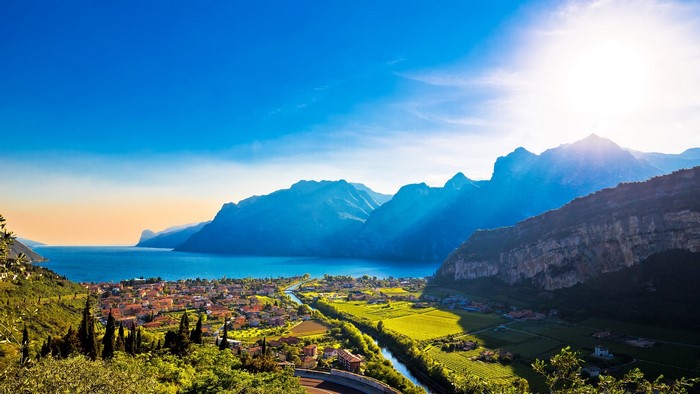 Lake Garda town with mountains and sun