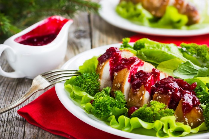 Sliced chicken breast with cranberry sauce and salad