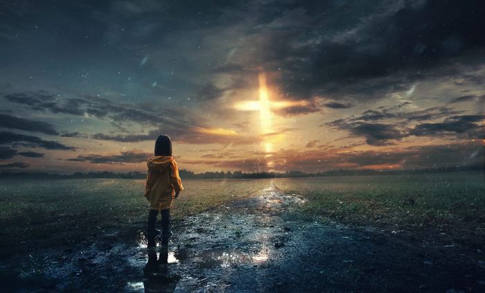 Girl in yellow raincoat looking at a glowing cross