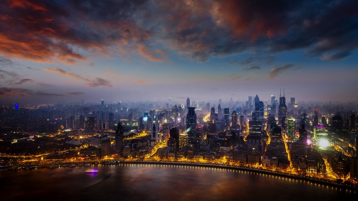 Shanghai cityscape at sunset with river and boats