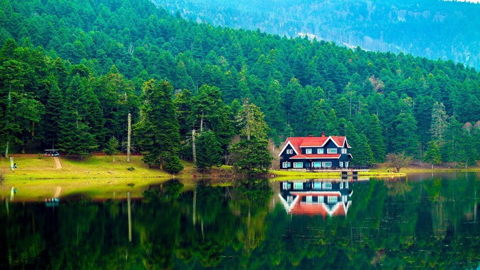 House by the lake with forest reflection