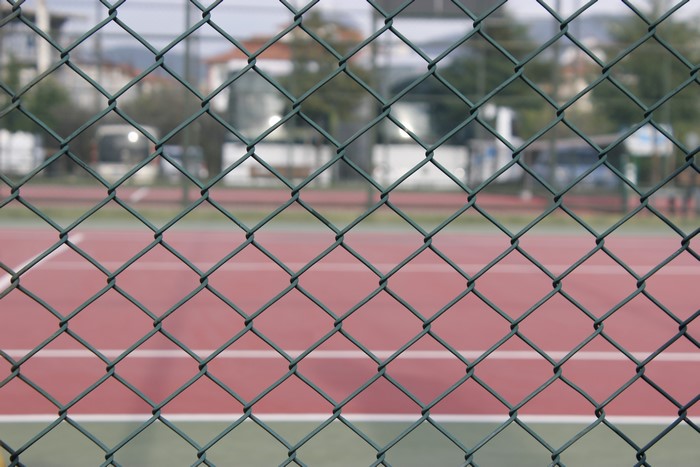 Chain-link fence in front of a tennis court