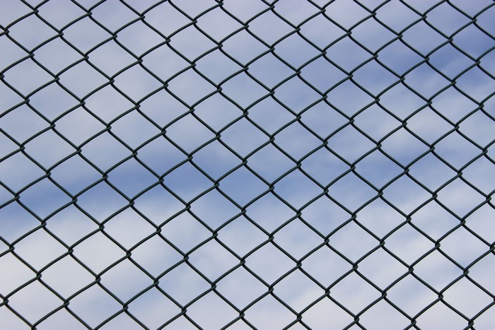 Chain-link fence against a cloudy sky
