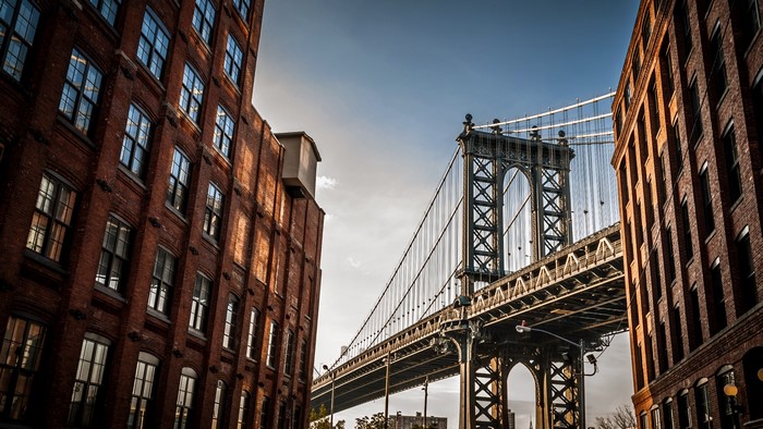 Manhattan Bridge between brick buildings in New York City