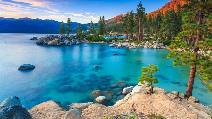 Lake Tahoe landscape with mountains, trees, and clear blue water