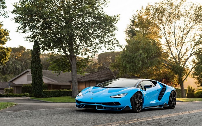 Blue Lamborghini Centenario driving on a road