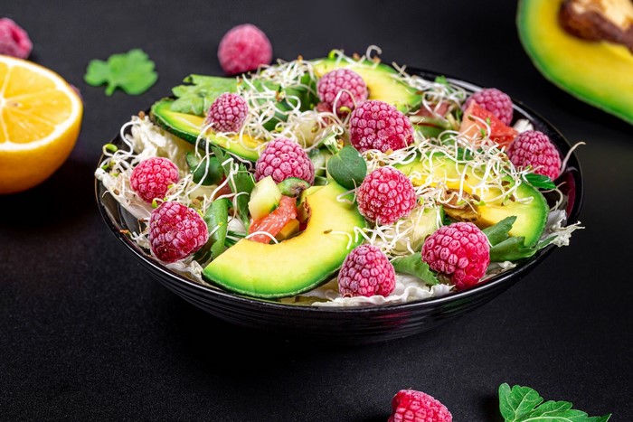 Salad with raspberries, avocado, sprouts, and lemon