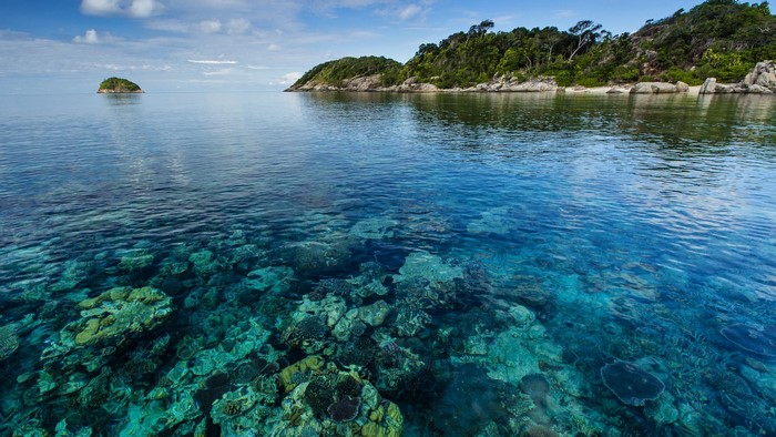 Clear turquoise water over coral reef near islands