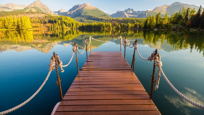 Wooden pier on a calm lake with Tatra Mountains in the background