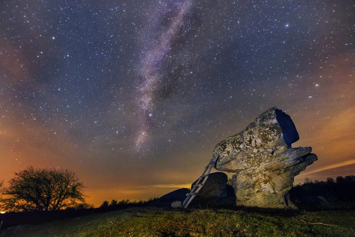 Milky Way over rock formation with ladder