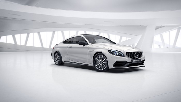 White Mercedes-Benz C63 AMG Coupe in a modern showroom