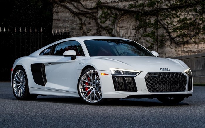 White Audi R8 V10 parked in front of a stone building