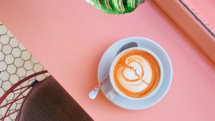 Latte art coffee cup on a pink table