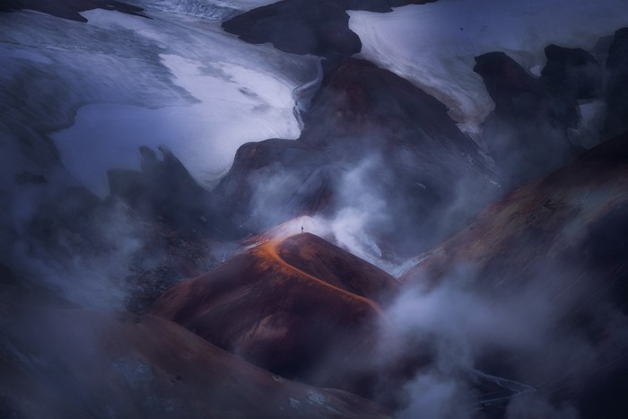 Man on mountain peak with mist and snow