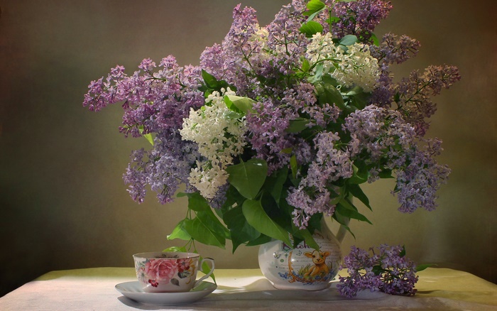 Still life photography of lilacs in a vase with a teacup