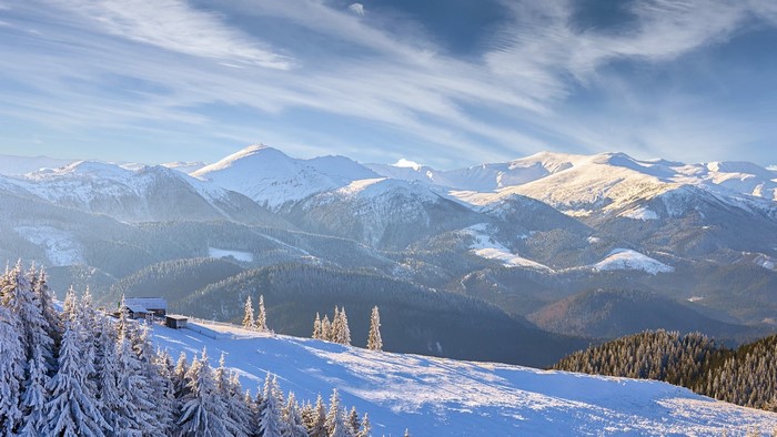 Snowy mountain landscape with a house and trees