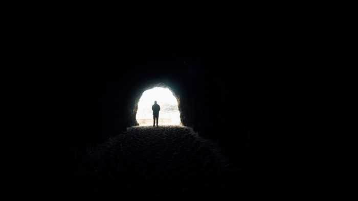 Silhouette of a person in a dark tunnel