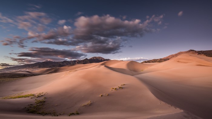 Sand dunes and mountains at sunset