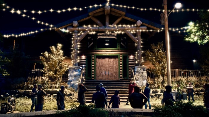 People gathered outside a log cabin decorated with string lights at night