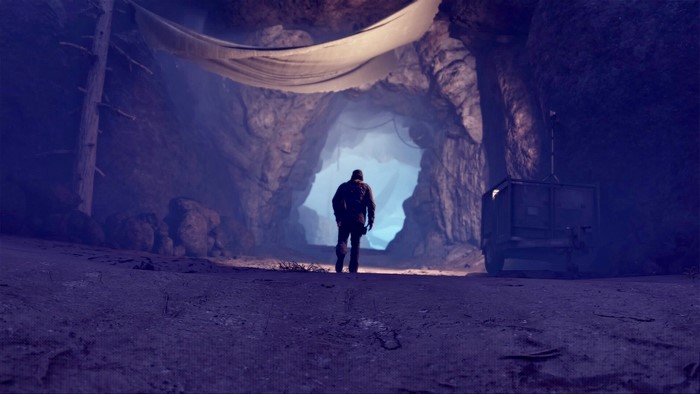 Man walking into a cave entrance in Days Gone