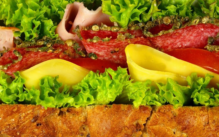 Close-up of a sandwich with salami, cheese, and lettuce