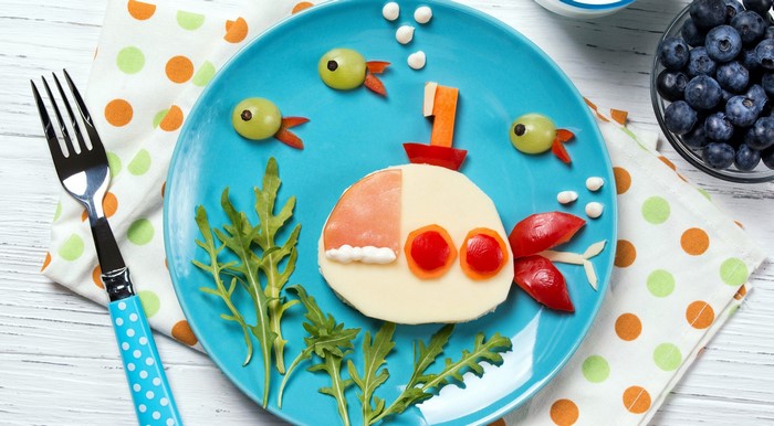 Submarine made of food on a blue plate with fish and blueberries