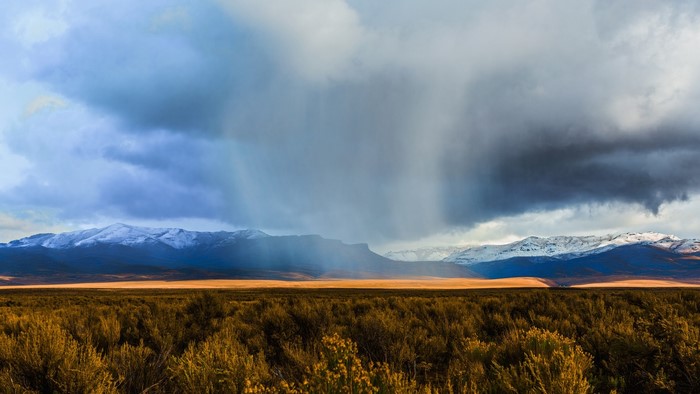 Rain falling on snowy mountains in Nevada landscape
