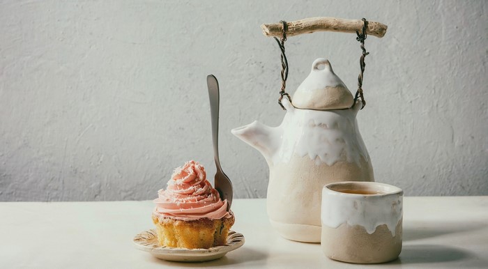 Cupcake with pink frosting and a teapot