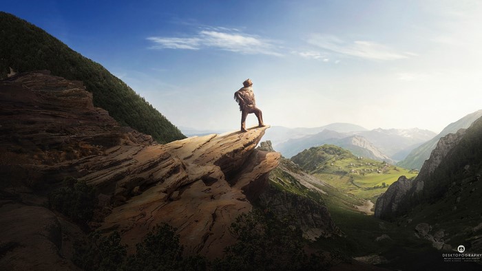 Hiker on a cliff overlooking mountains